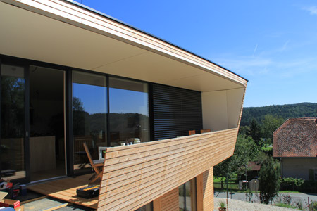 Wohnhaus mit Holzfassade und Balkon